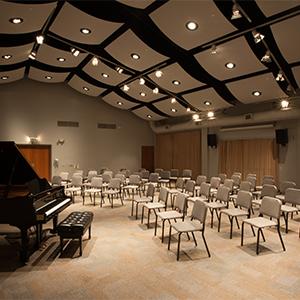 CADE Rehearsal space with chairs and piano.