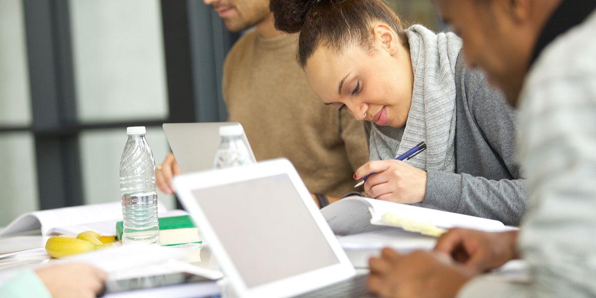 Female student studying with a group.